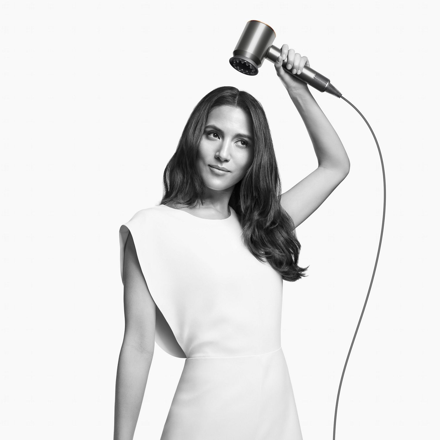 Woman with the Dyson Supersonic hair dryer with the gentle hair attachment. 